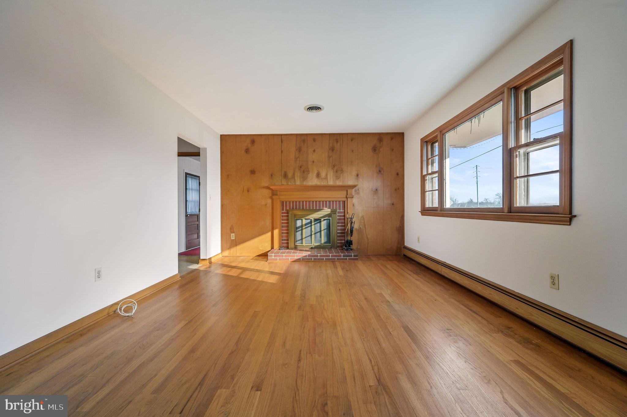 955 Twin Willows Road Smyrna, DE 19977 - Photo 14 of 27 an empty room with wooden floor fireplace and windows