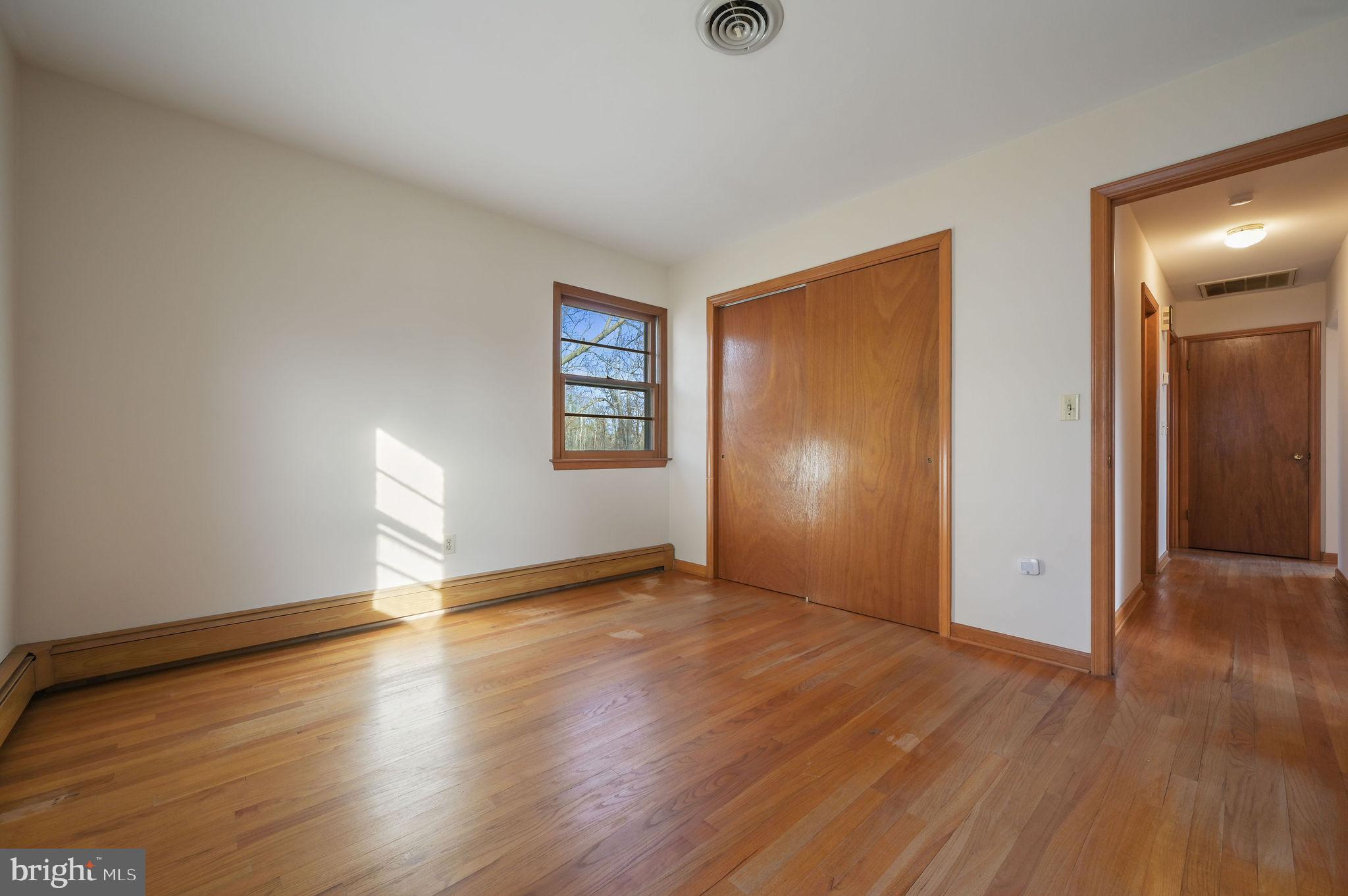 955 Twin Willows Road Smyrna, DE 19977 - Photo 21 of 27 an empty room with wooden floor and windows with curtains