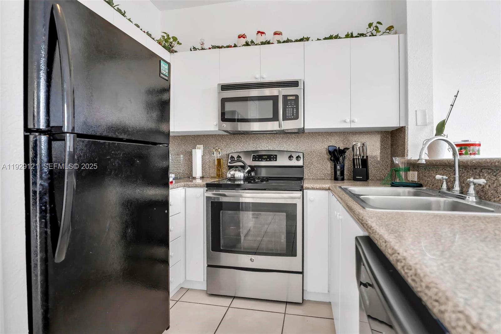 17710 Northwest 73rd Avenue, Unit 20120 Hialeah, FL 33015 - Photo 17 of 39 a kitchen with stainless steel appliances granite countertop a refrigerator a stove and a sink with wooden floor