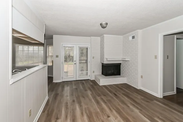 a view of a kitchen with wooden floor and electronic appliances
