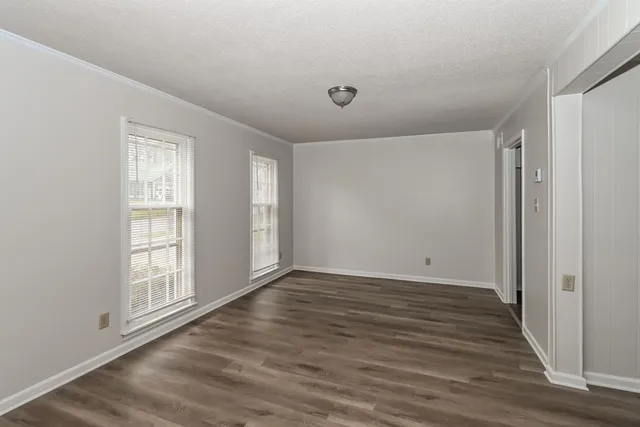 a view of empty room with wooden floor and fireplace