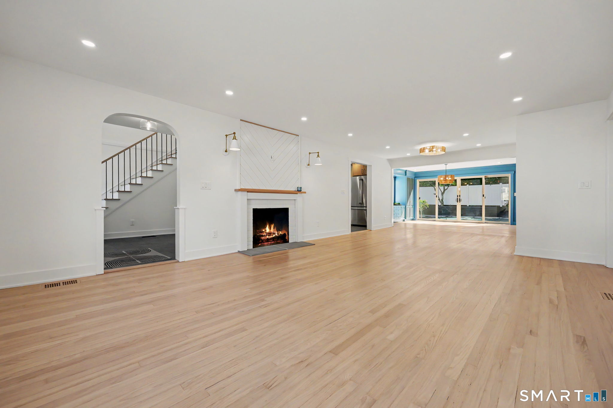 91 Lockwood Road Fairfield, CT 06825 - Photo 5 of 38 a view of an empty room with wooden floor fireplace and a window