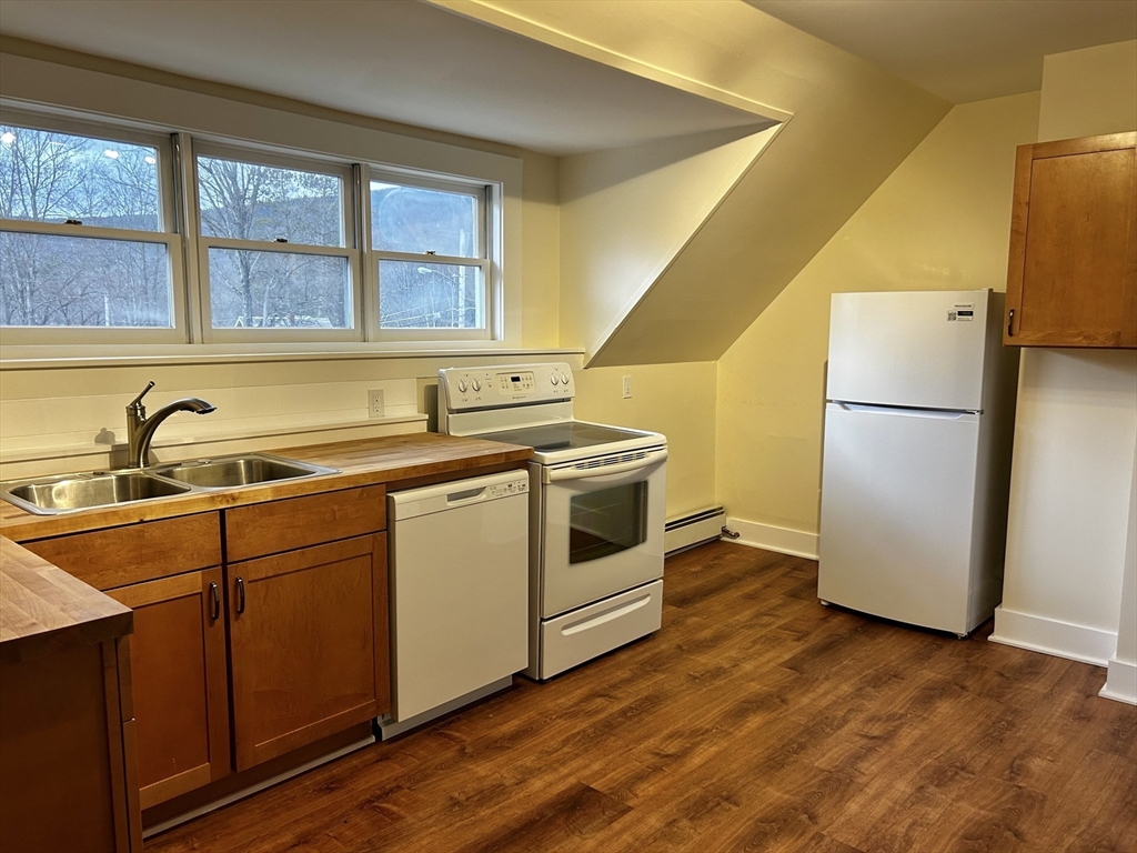 46 Elm Street, Unit 2 Buckland, MA 01370 - Photo 2 of 15 a kitchen with a sink a refrigerator and wooden cabinets