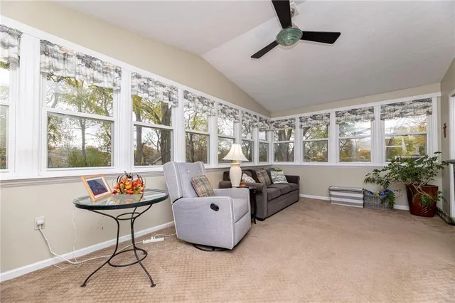 a living room with furniture and floor to ceiling windows