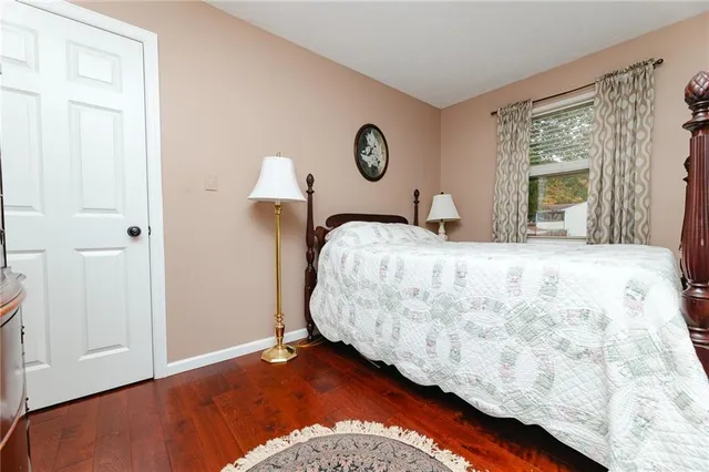 a bedroom with a bed and a lamp on dresser