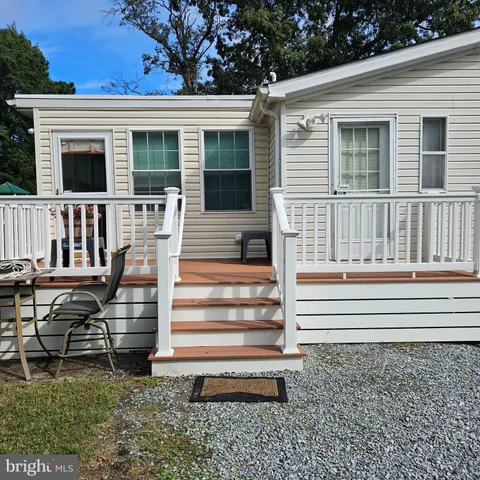 a view of a house with a wooden deck and a floor to ceiling window