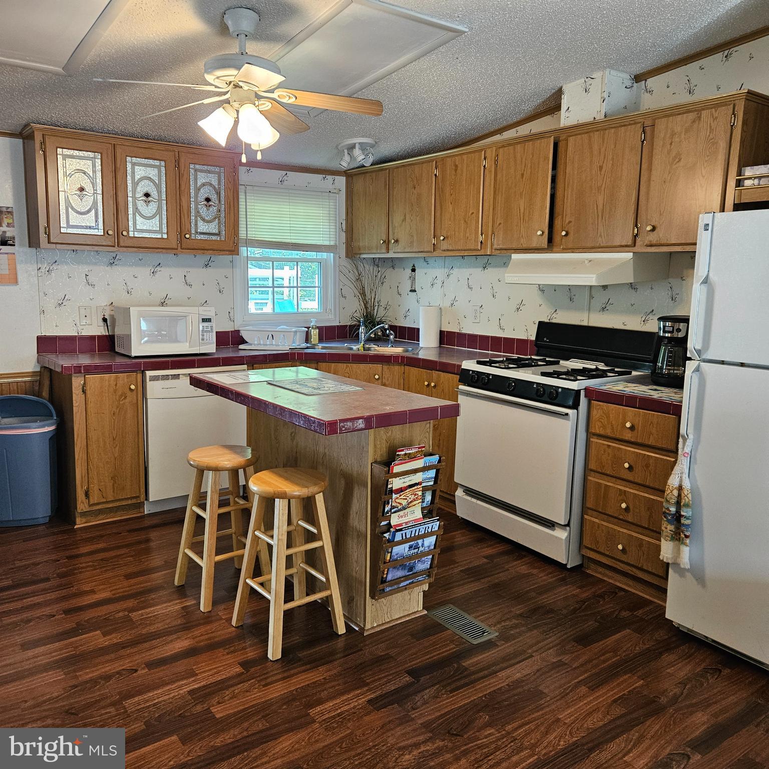 24212 Durham Street Georgetown, DE 19947 - Photo 7 of 21 a kitchen with stainless steel appliances granite countertop a stove top oven a refrigerator a sink and dishwasher with wooden floor