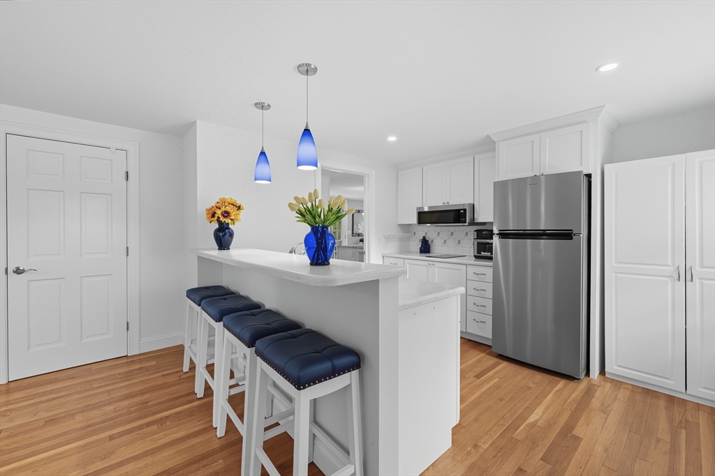40 East Street Topsfield, MA 01983 - Photo 24 of 39 a kitchen with a refrigerator a stove and wooden floor