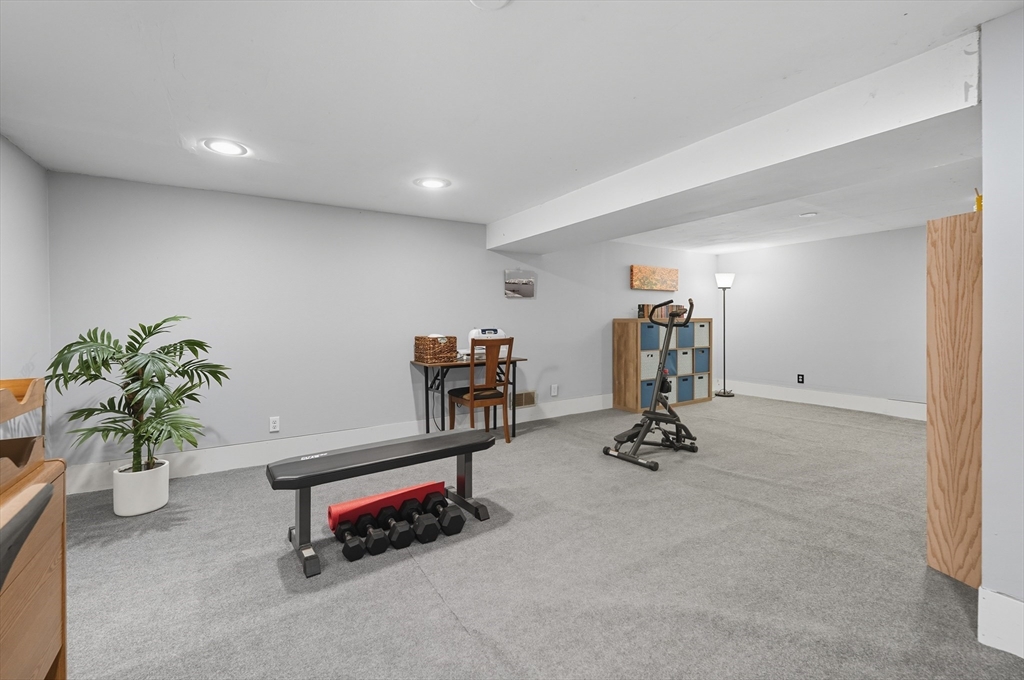 40 East Street Topsfield, MA 01983 - Photo 30 of 39 a living room with furniture gym equipment and a potted plant