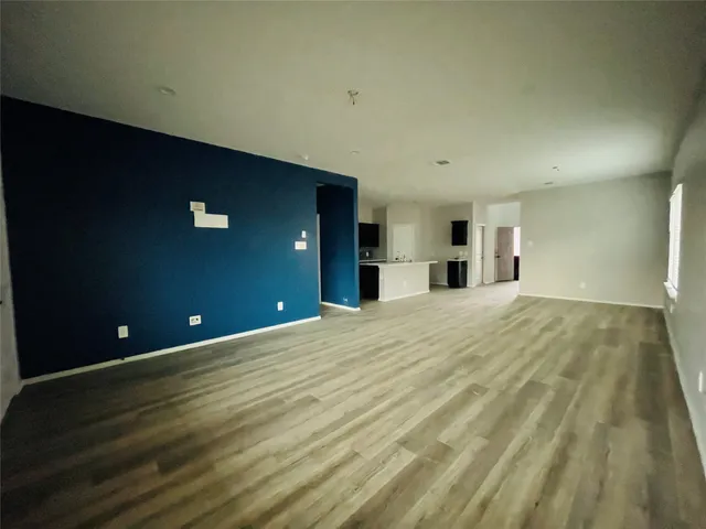 a view of a livingroom with wooden floor and a ceiling fan