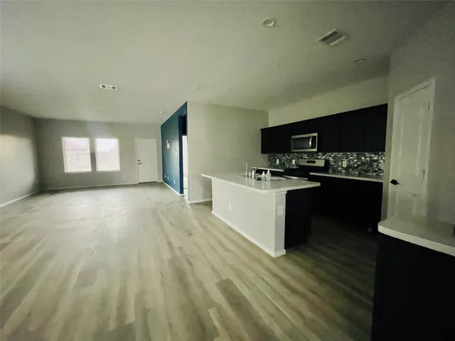 a kitchen with stainless steel appliances a refrigerator and a stove top oven