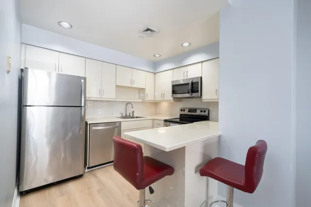 a kitchen with stainless steel appliances granite countertop a refrigerator stove a sink and a microwave