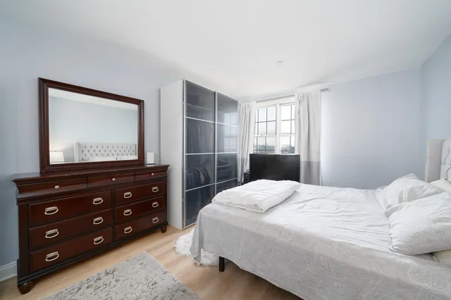 a bedroom with a bed and a mirror on dresser