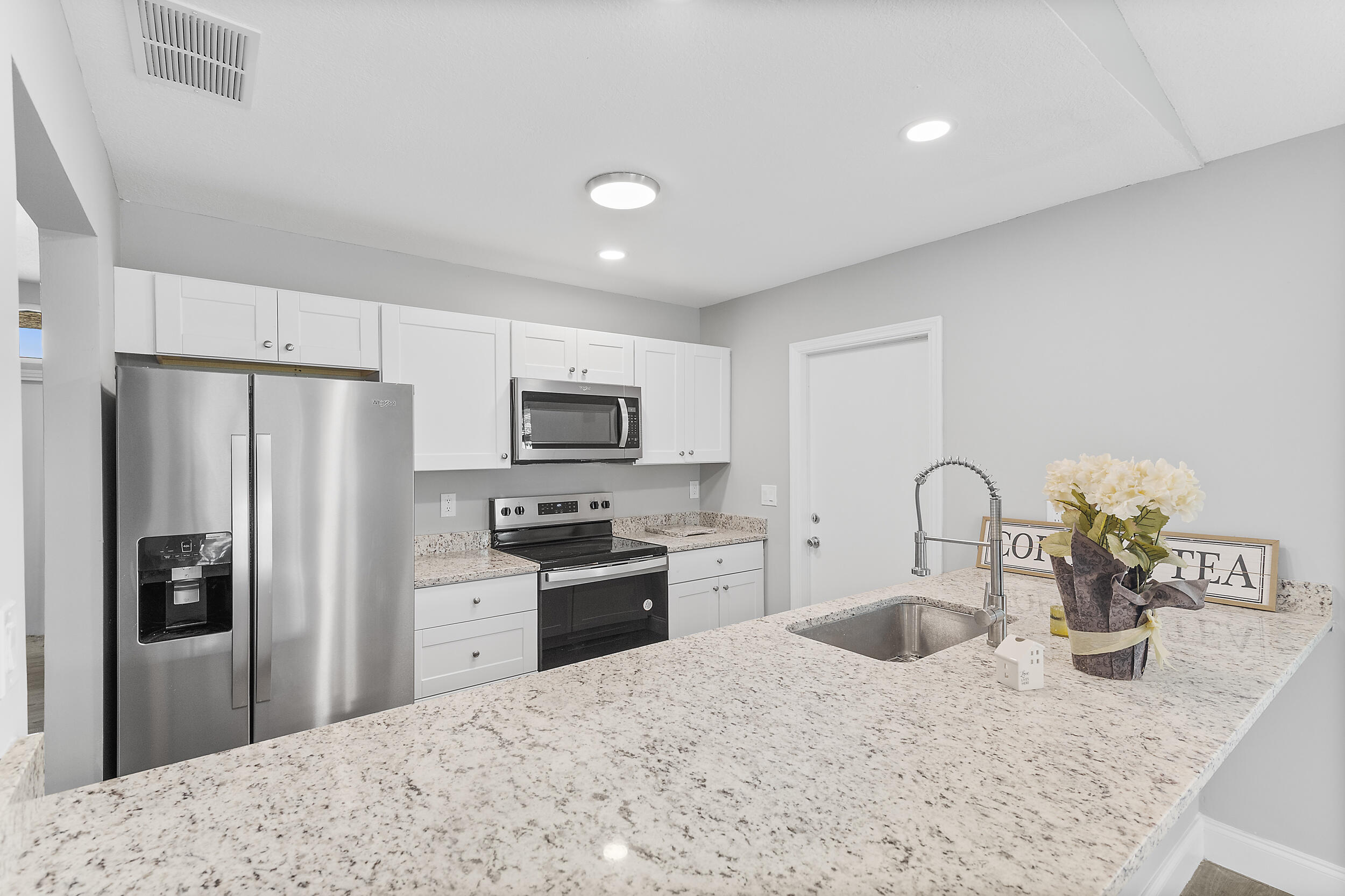 a kitchen with stainless steel appliances kitchen island a refrigerator sink and stove