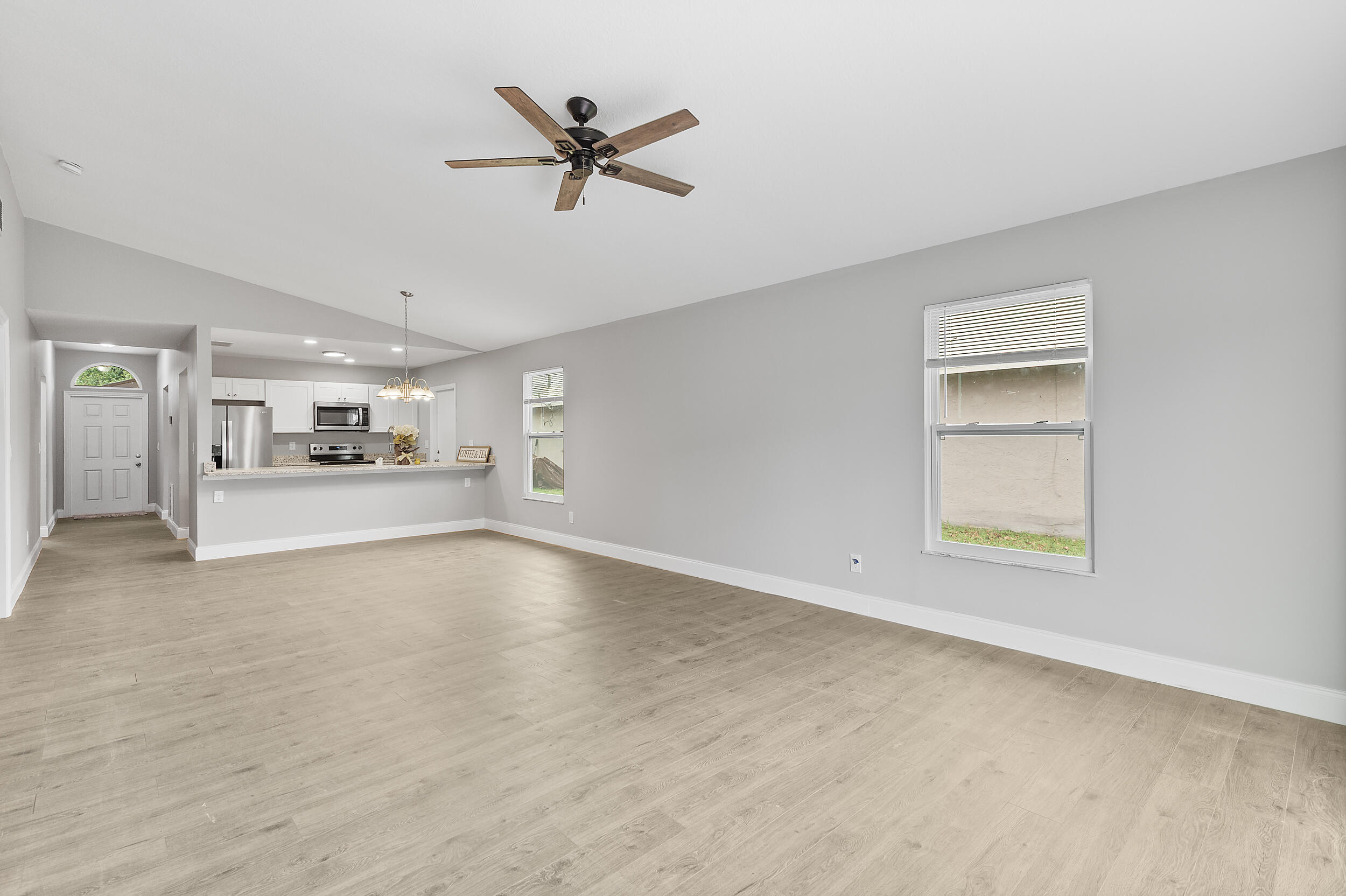 4777 Southeast Salvatori Road Stuart, FL 34997 - Photo 17 of 28 a view of a livingroom with a fireplace a ceiling fan and wooden floor