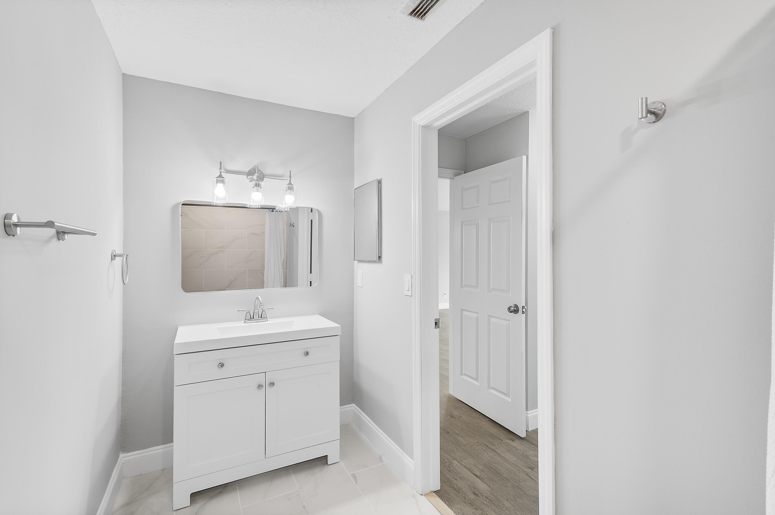 4777 Southeast Salvatori Road Stuart, FL 34997 - Photo 22 of 28 a bathroom with a double vanity sink a toilet and a mirror