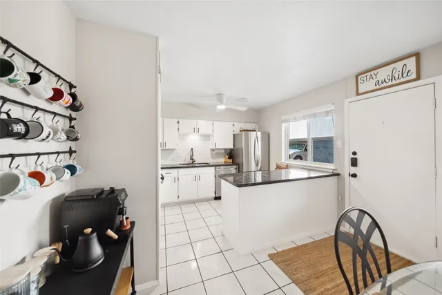 a kitchen with stainless steel appliances a sink a stove a refrigerator and cabinets
