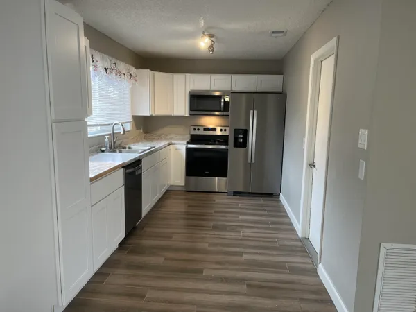 a kitchen with sink a microwave and cabinets