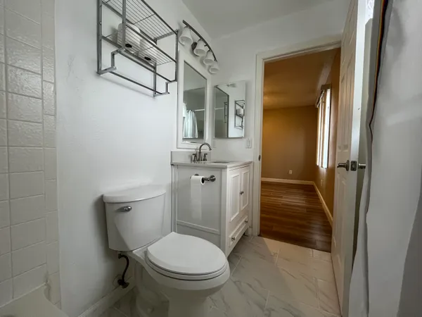 a bathroom with a granite countertop toilet sink and shower