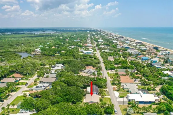 an aerial view of residential houses with outdoor space and trees