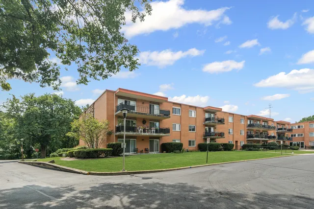 a view of a big building with a big yard and large trees