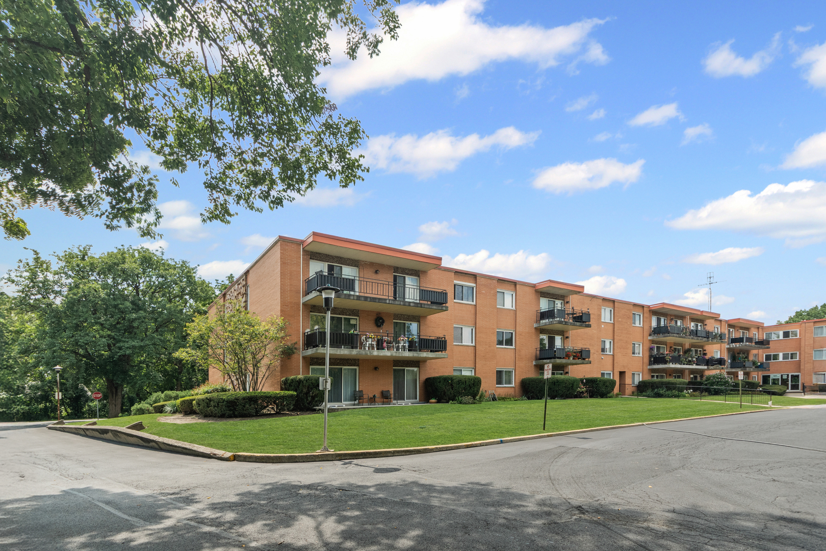 a view of a big building with a big yard and large trees
