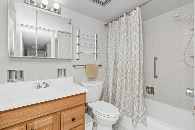 a bathroom with a sink toilet vanity and shower