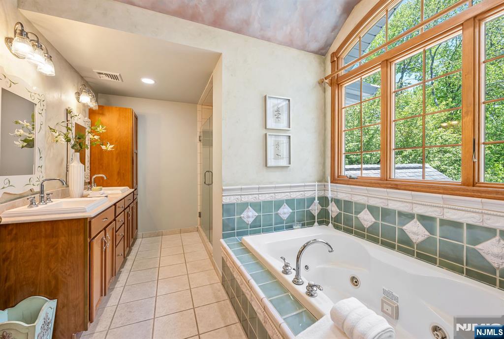 411 Snyder Road Wyckoff, NJ 07481 - Photo 19 of 36 a bathroom with a granite countertop tub a sink and a large window