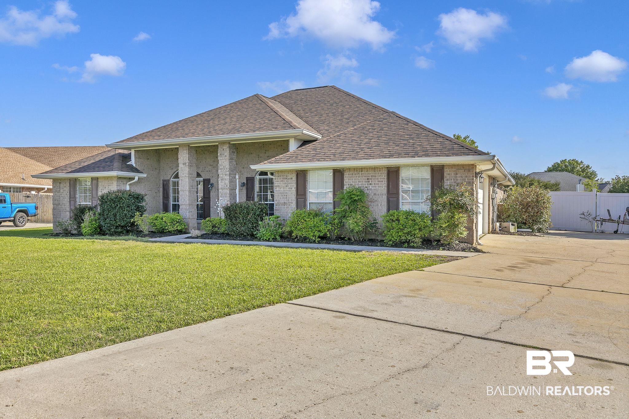 16358 Tempest Drive Foley, AL 36535 - Photo 46 of 46 Single story home featuring roof with shingles, concrete driveway, fence, brick siding, and a front yard