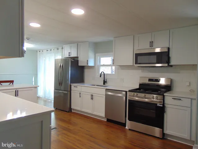 a kitchen with stainless steel appliances a stove a sink and a refrigerator