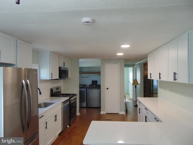 a kitchen with stainless steel appliances a refrigerator and a stove top oven