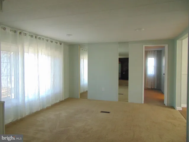 an empty room with windows and bathroom view