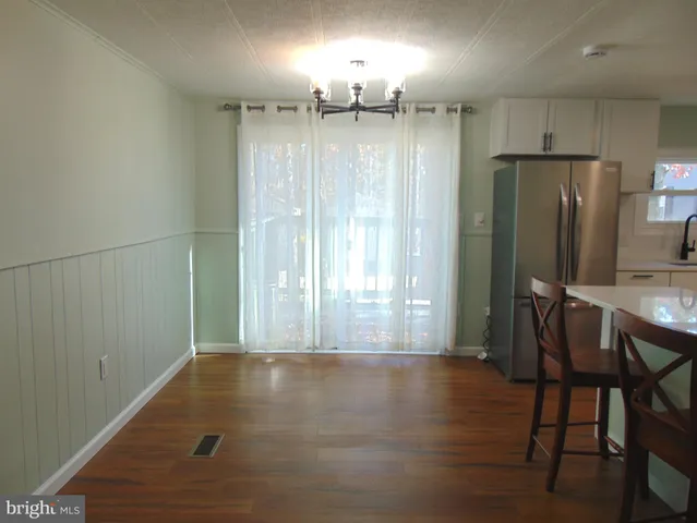 a view of a kitchen with wooden floor and a refrigerator