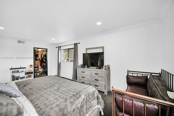 a bedroom with a bed and flat screen tv