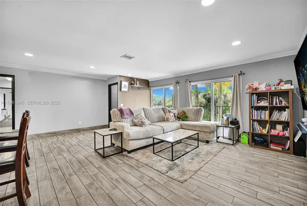 a living room with furniture and a wooden floor
