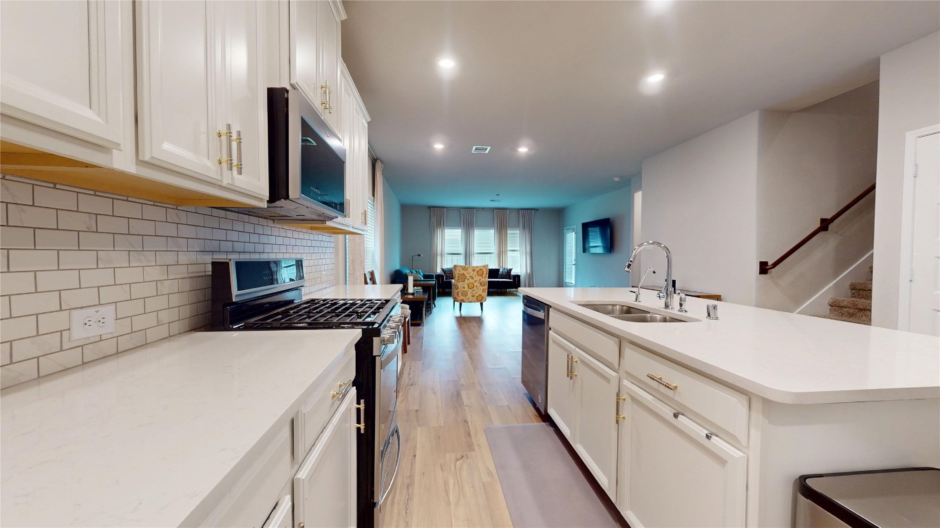 21606 Reserve Ranch Trail Richmond, TX 77407 - Photo 13 of 48 a kitchen with sink a stove and cabinets
