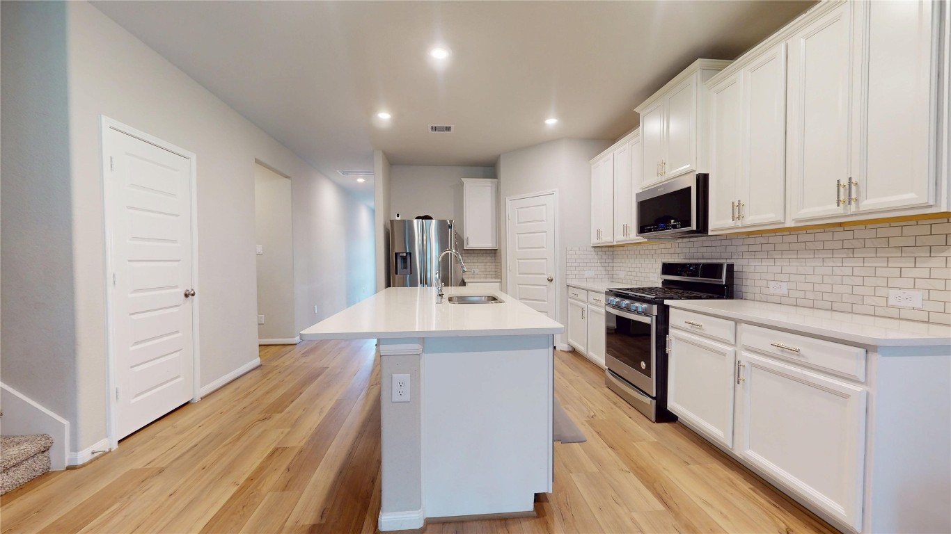 21606 Reserve Ranch Trail Richmond, TX 77407 - Photo 18 of 48 a kitchen with kitchen island a sink stainless steel appliances and cabinets