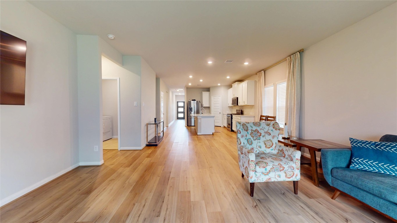 21606 Reserve Ranch Trail Richmond, TX 77407 - Photo 25 of 48 a view of a living room and kitchen with furniture wooden floor and windows