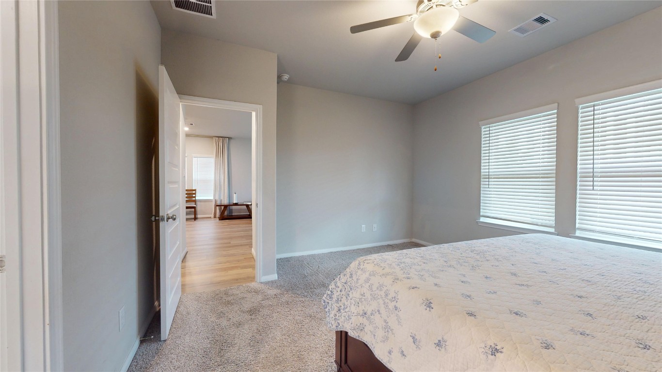 21606 Reserve Ranch Trail Richmond, TX 77407 - Photo 28 of 48 a bedroom with a bed and a chandelier