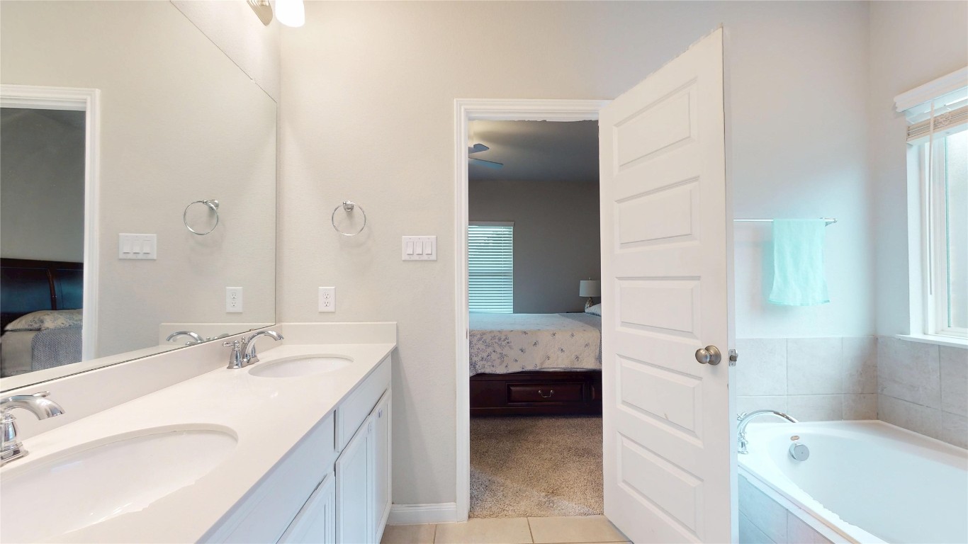 21606 Reserve Ranch Trail Richmond, TX 77407 - Photo 32 of 48 a bathroom with a granite countertop sink and a bathtub