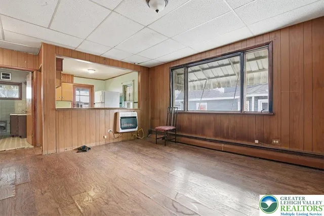 a view of a hallway with wooden floor and a bathroom