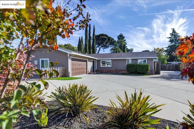 a front view of a house with a yard and potted plants