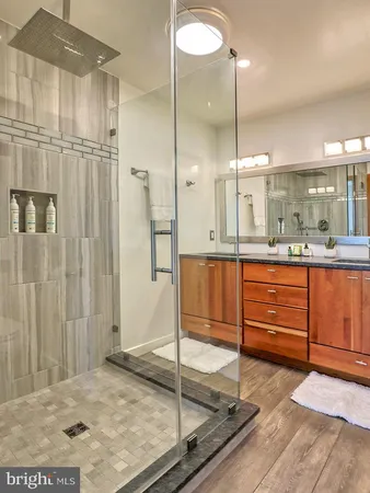 a bathroom with a granite countertop sink mirror and shower