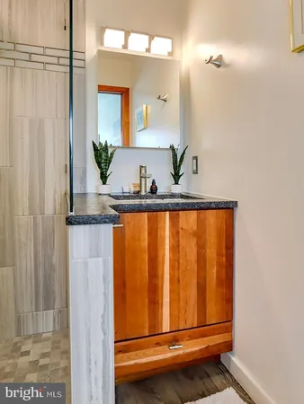 a bathroom with a granite countertop sink and a mirror