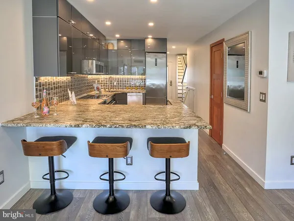 a kitchen with stainless steel appliances granite countertop a sink and a refrigerator