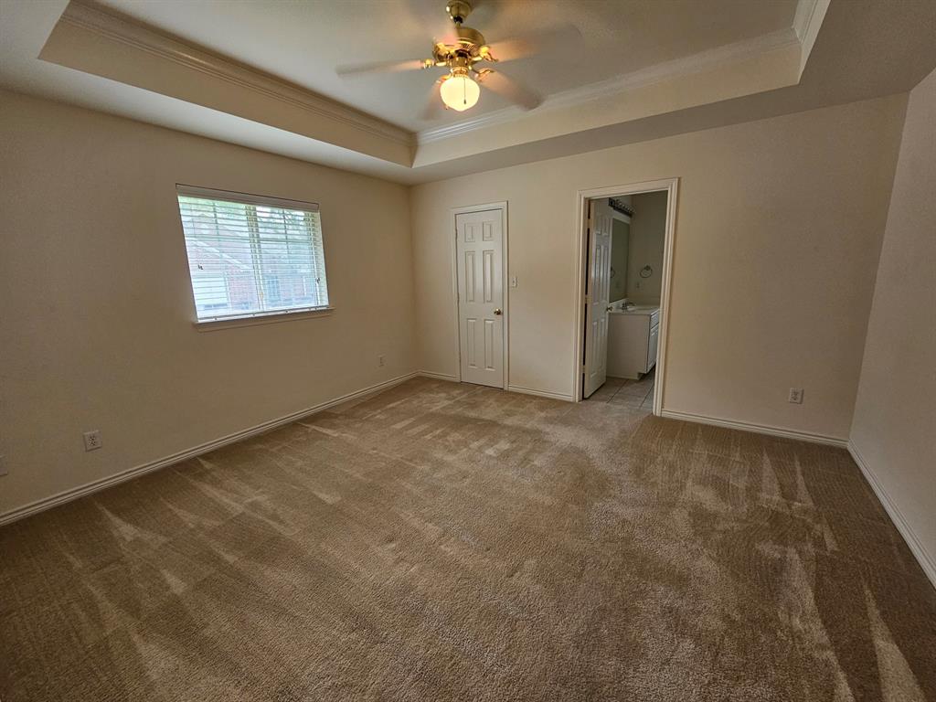 1521 Rice Road, Unit Z101 Tyler, TX 75703 - Photo 11 of 25 Recessed ceiling detail with crown molding, ceiling fan with light fixture, and neutral carpeted flooring