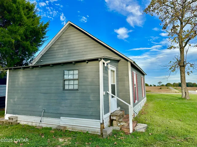 a backyard of a house with table and chairs