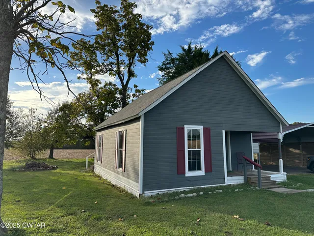 a front view of house with a garden