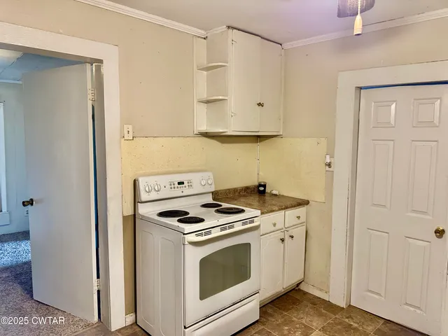 a kitchen with white cabinets and white appliances