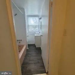 a bathroom with a tub sink and mirror